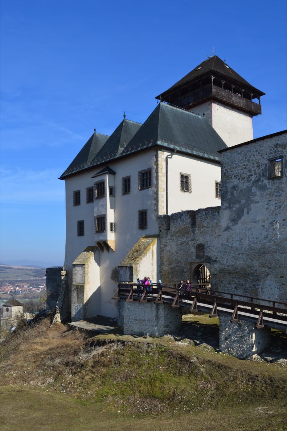 The towering medieval ramparts of Trenčín Castle perched high above the Váh River and red-tiled old town roofs