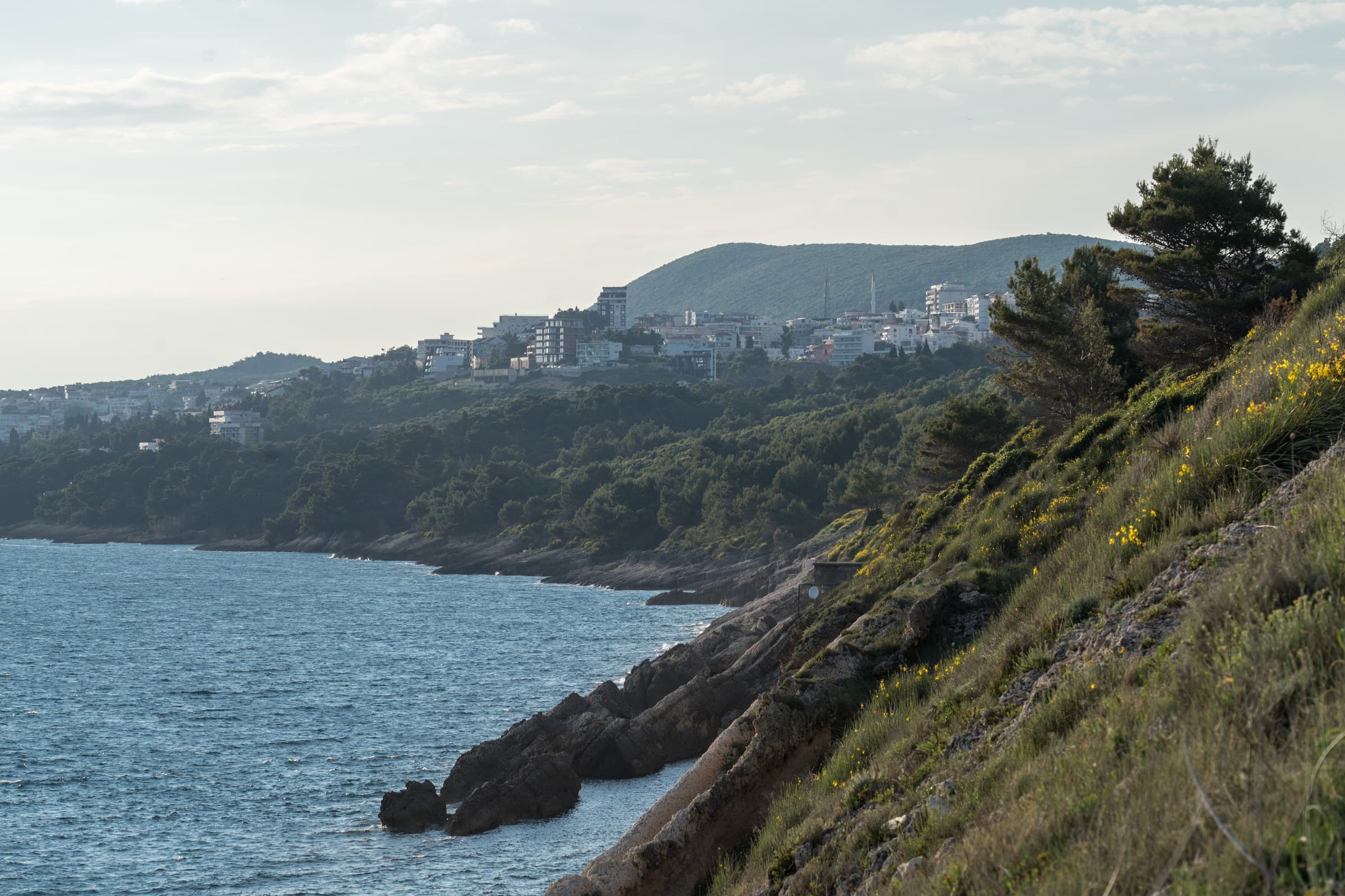 Ancient stone fortress bastions of Ulcinj rising directly out of the crashing blue Adriatic waves