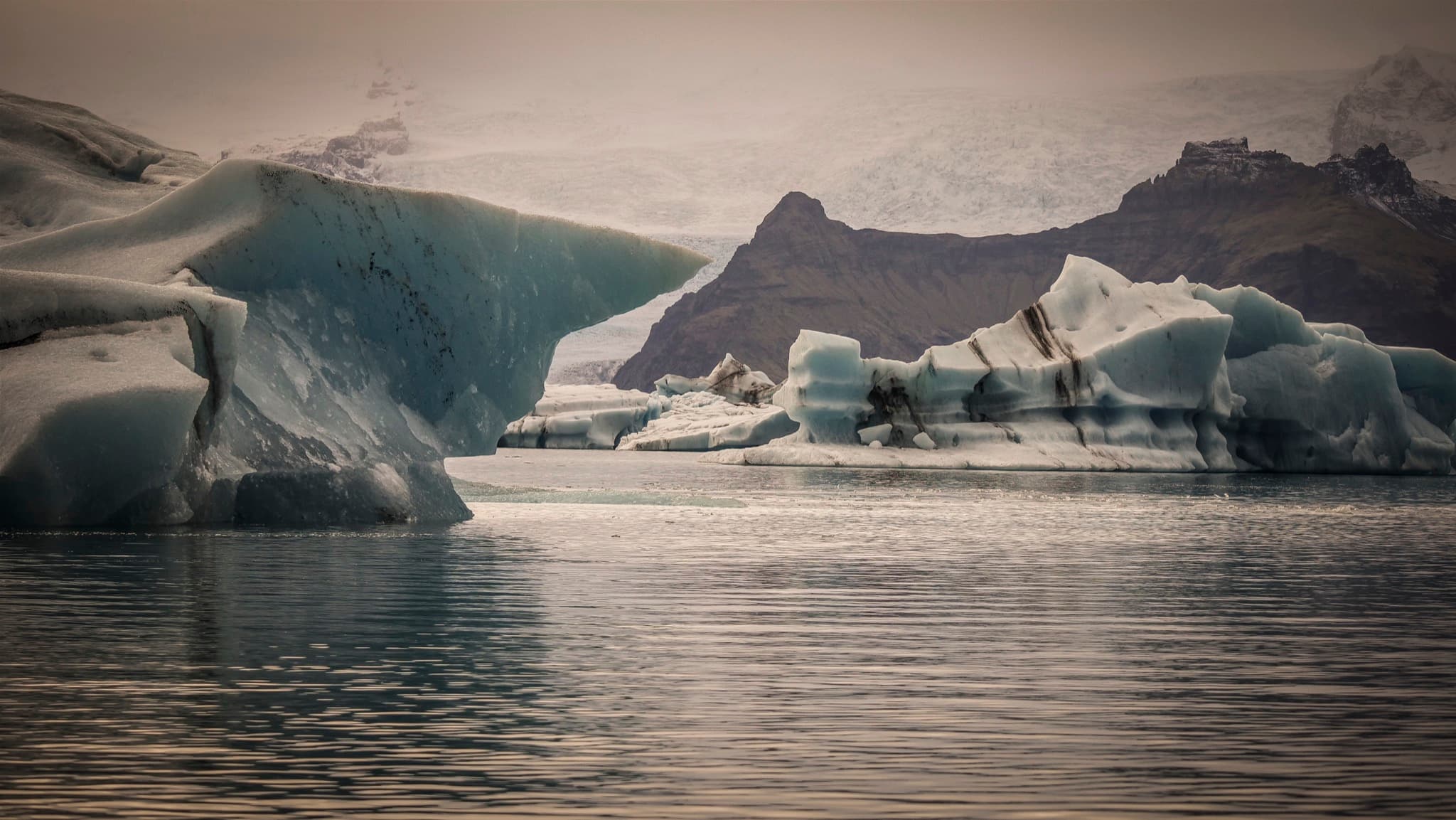 Sculpted blue icebergs drifting in Jökulsárlón glacier lagoon below Vatnajökull