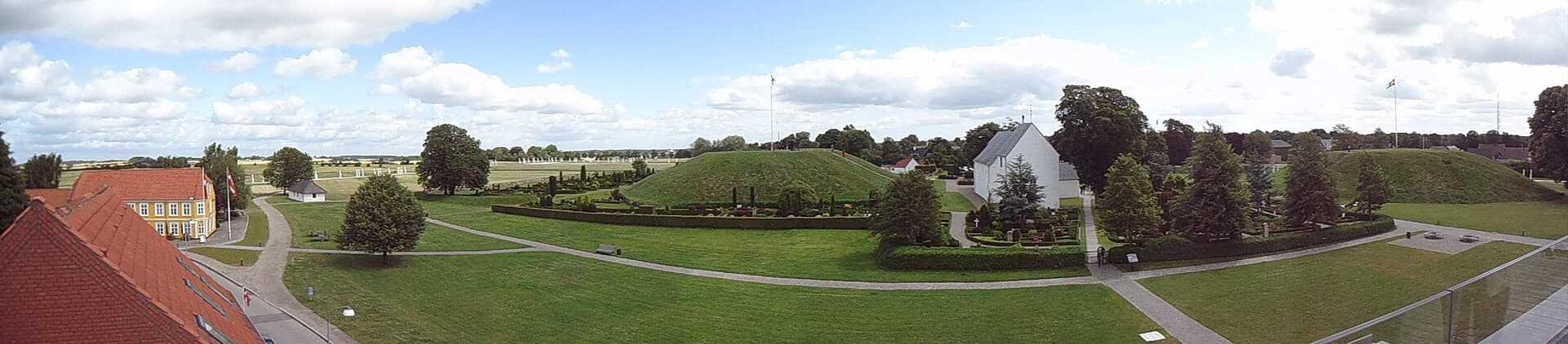 Jelling Church flanked by the monumental royal Viking burial mounds of King Gorm and Queen Thyra.