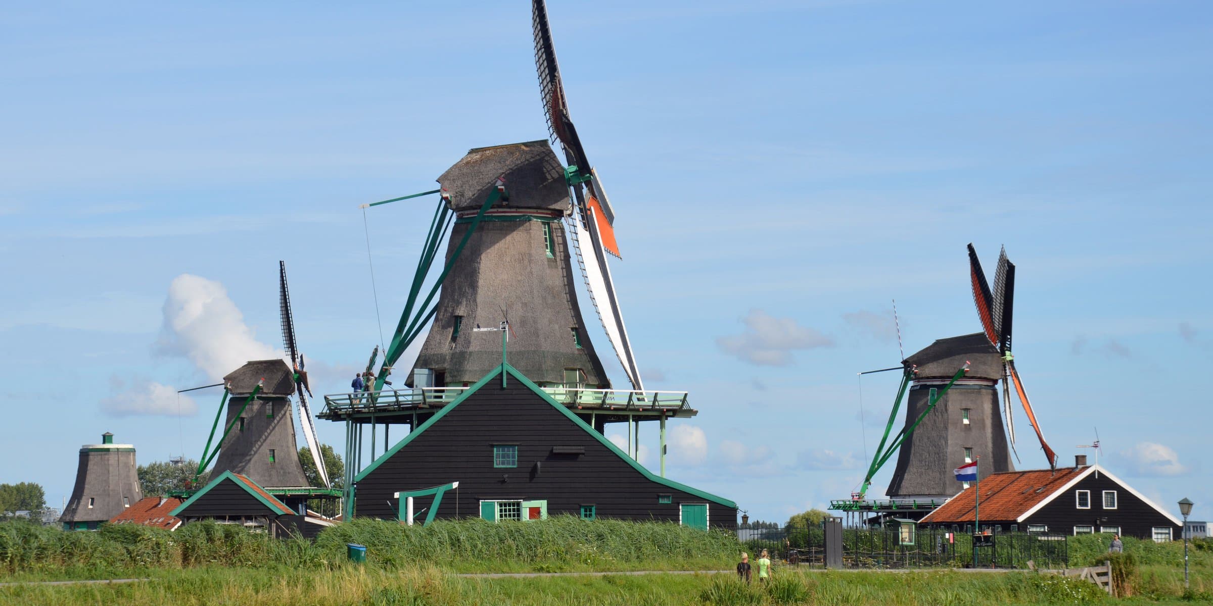 Historic green timber windmills and wooden cottages along the river Zaan at Zaanse Schans