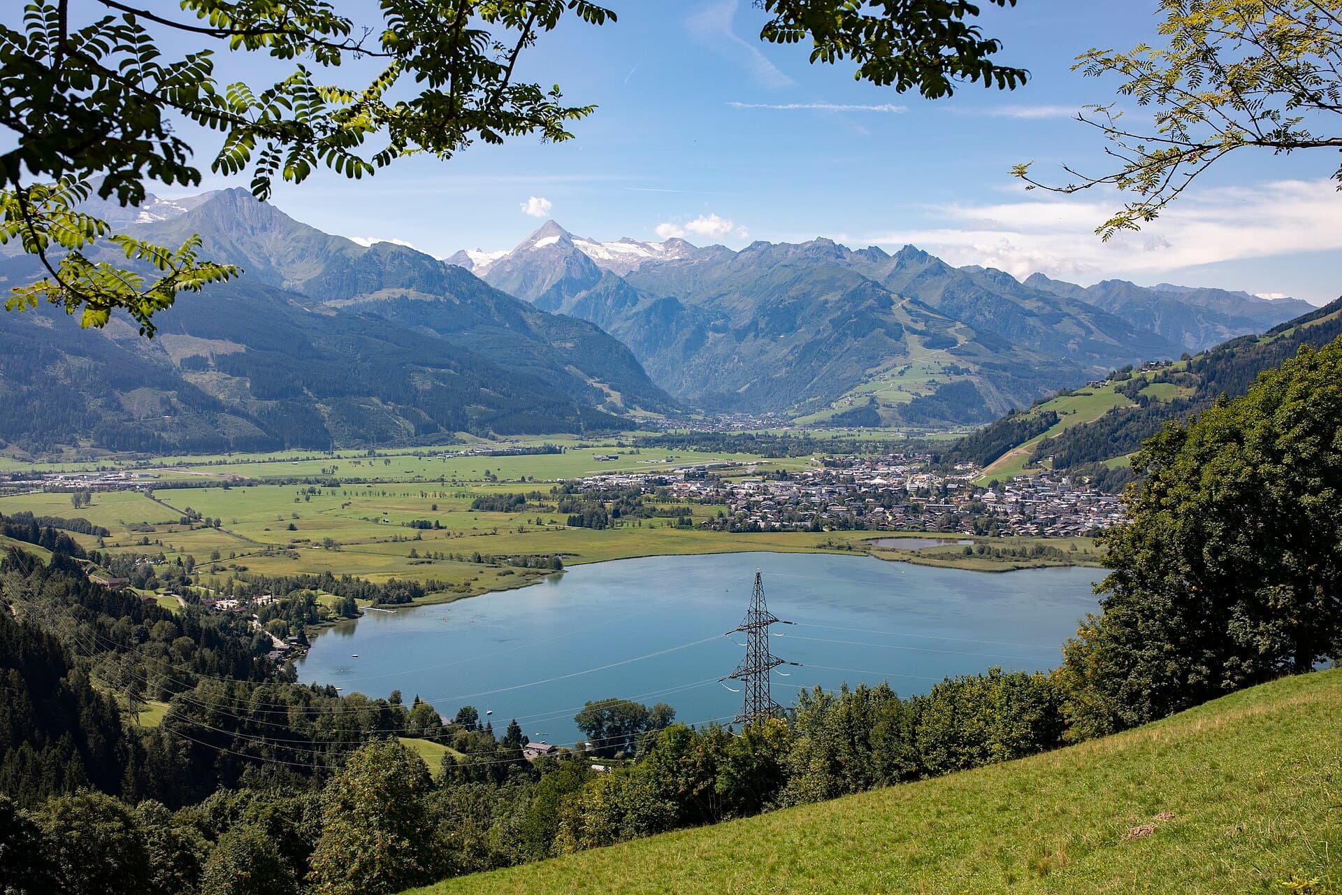 Crystalline waters of Lake Zell reflecting the snow-dusted summits of the Hohe Tauern mountain range