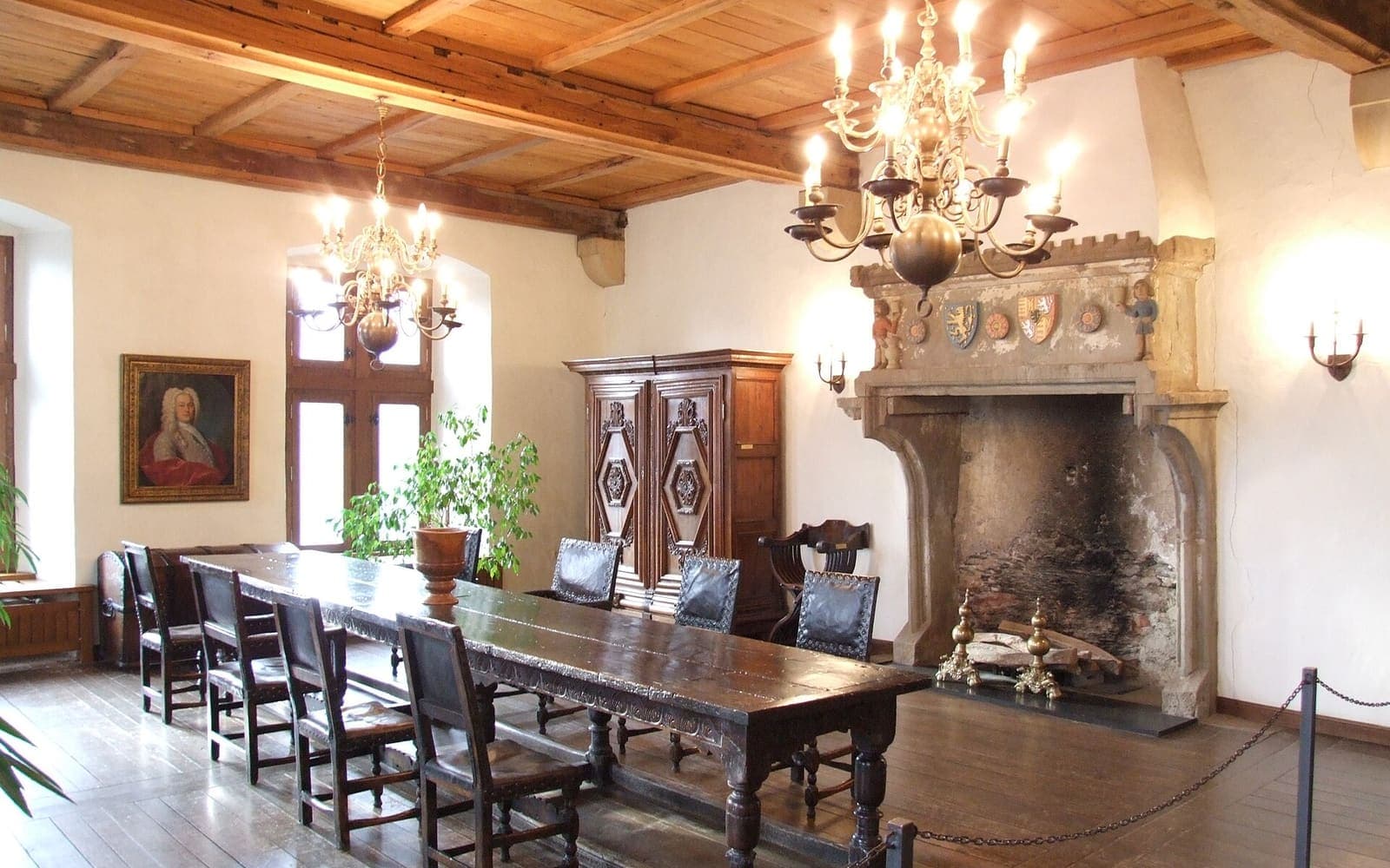 A furnished hall with a carved fireplace inside Vianden Castle