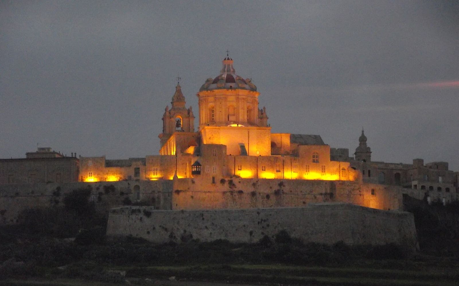 Mdina's walls and cathedral lit up at dusk