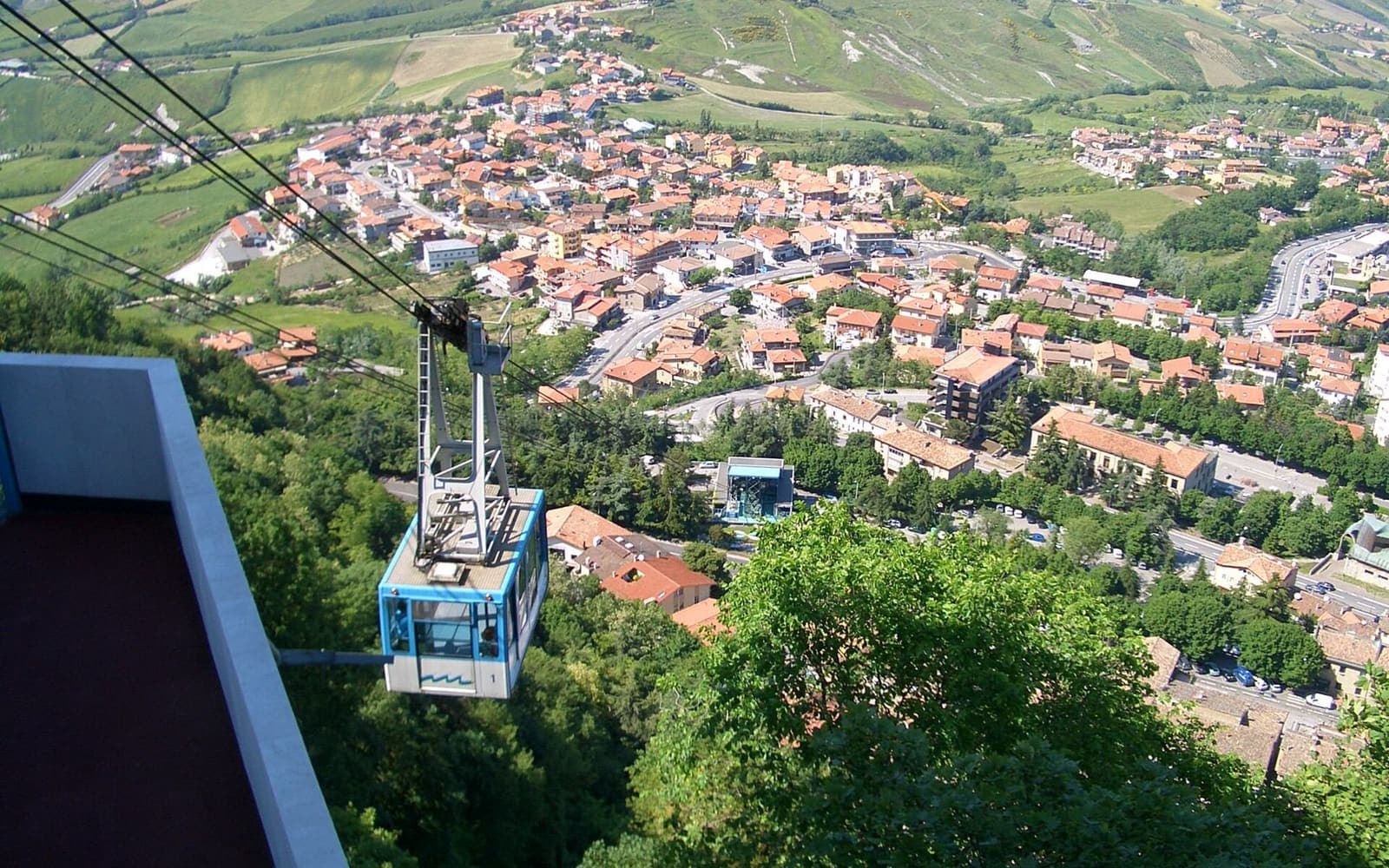 A cable car cabin above the roofs of Borgo Maggiore