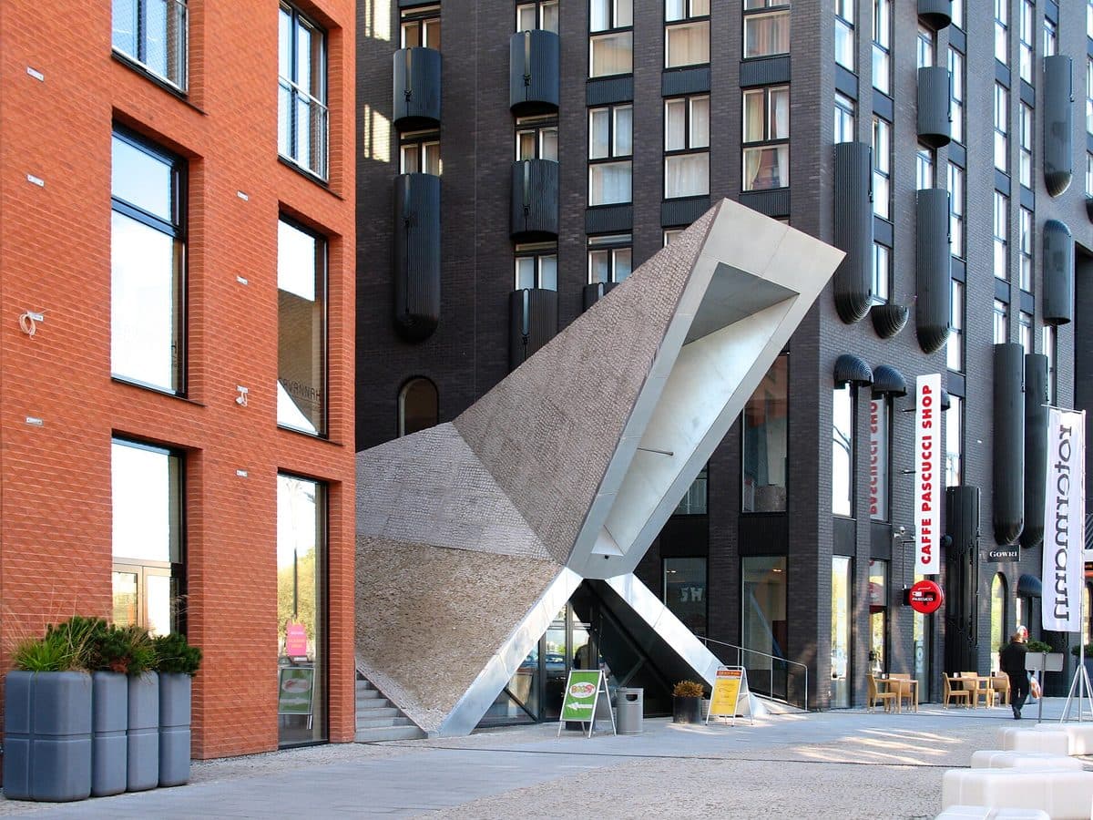 Limestone warehouse cut open with angular concrete and glass in Tallinn's Rotermann Quarter